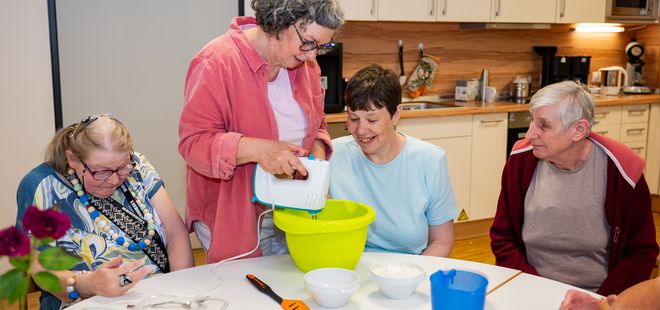 eine Gruppe Menschen backt Waffeln